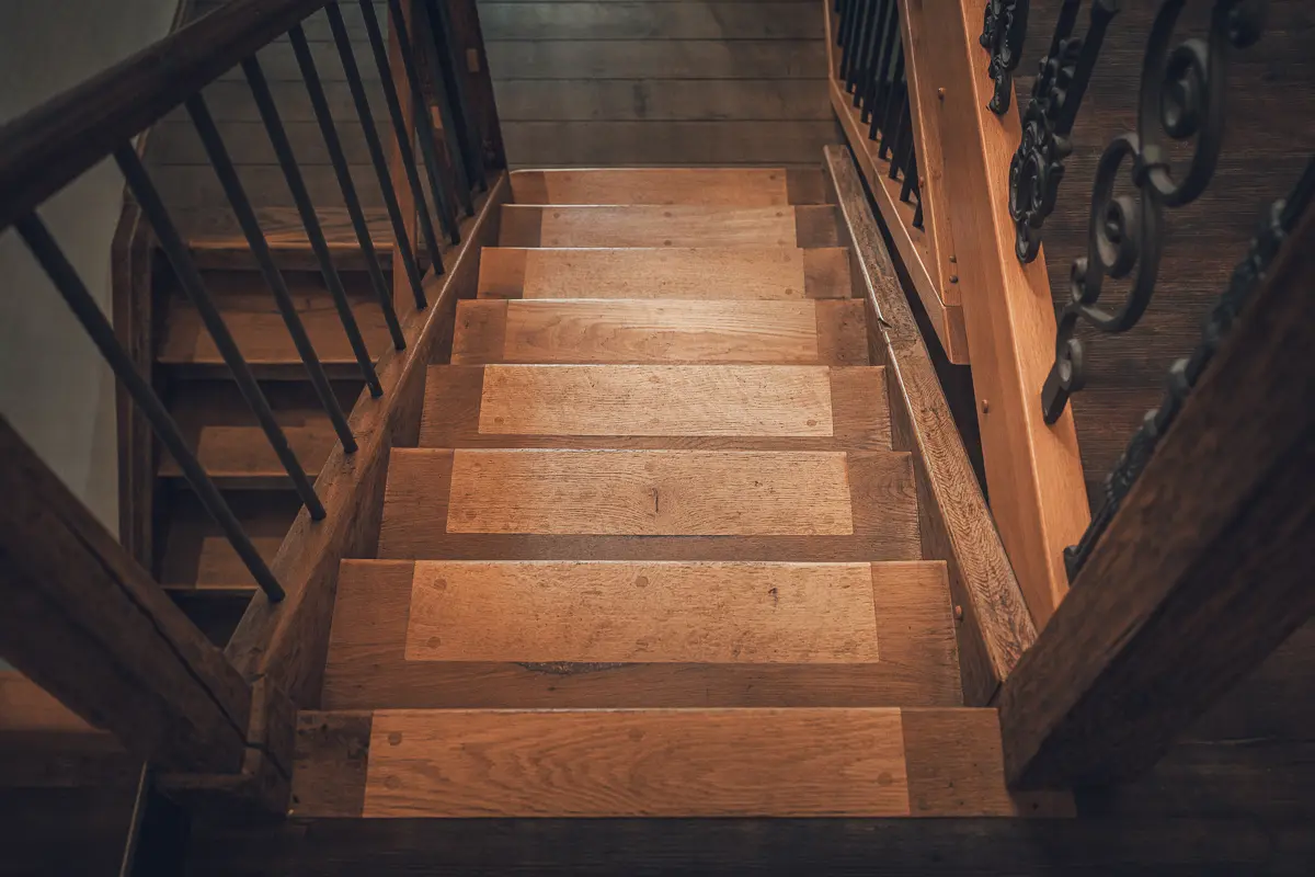 Restaurierte Holztreppe und Geländer erhalten und saniert statt abgerissen und neugebaut von Lauffer Holzbau-Zimmerei in Renningen. Wir schützen historische Bausubstanz und ergänzen mit nachhaltigen Baustoffen.